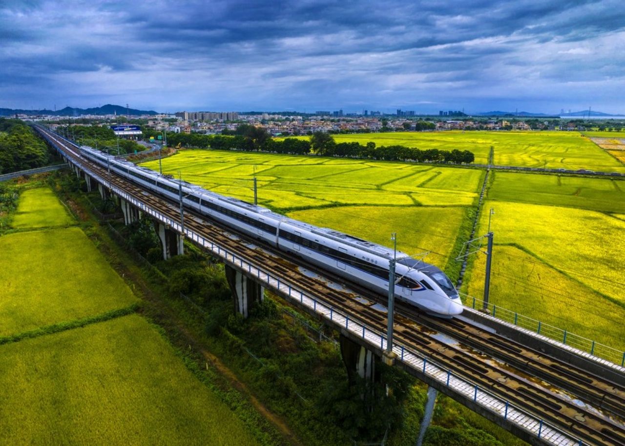  รถไฟหัวกระสุนวิ่งผ่านทุ่งนาข้าวในเมืองจงซาน มณฑลกว่างตงทางตอนใต้ของจีน 